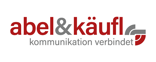 Logo von abel&käufl in rot und grau mit dem Slogan "Kommunikation verbindet", das unsere Teilnahme an der PMRExpo symbolisiert, wo wir innovative Lösungen im Bereich sicherheitskritischer Kommunikationstechnologien präsentieren.